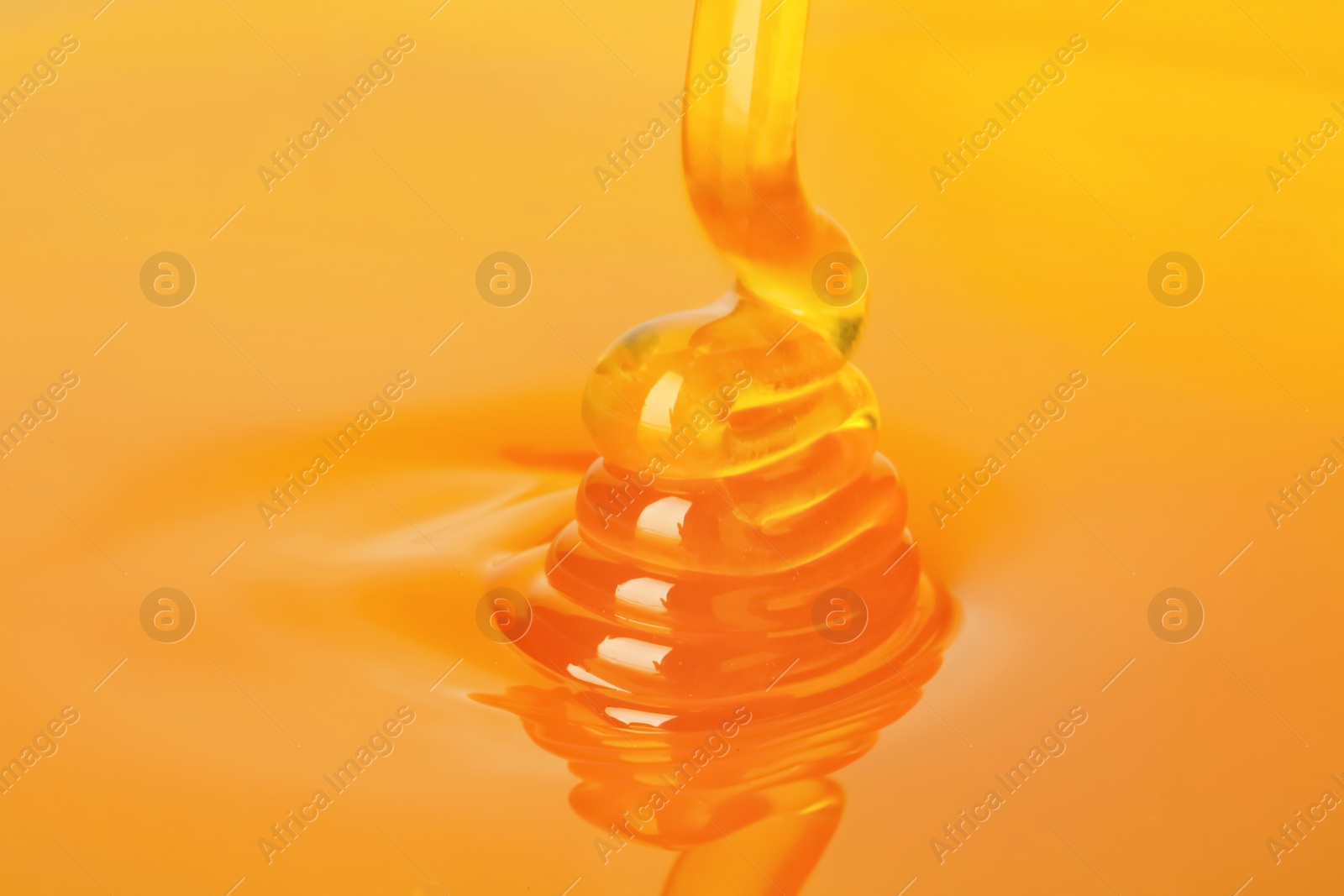 Photo of Pouring fresh sweet honey, closeup