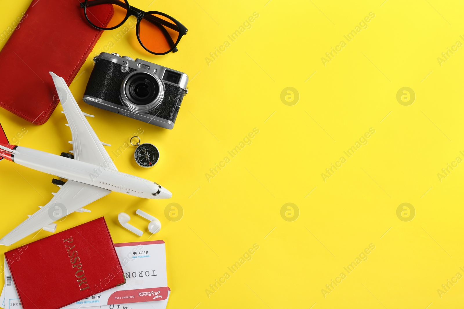 Photo of Flat lay composition with toy airplane and travel items on yellow background. Space for text