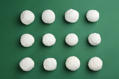 Round snowballs on green background, flat lay