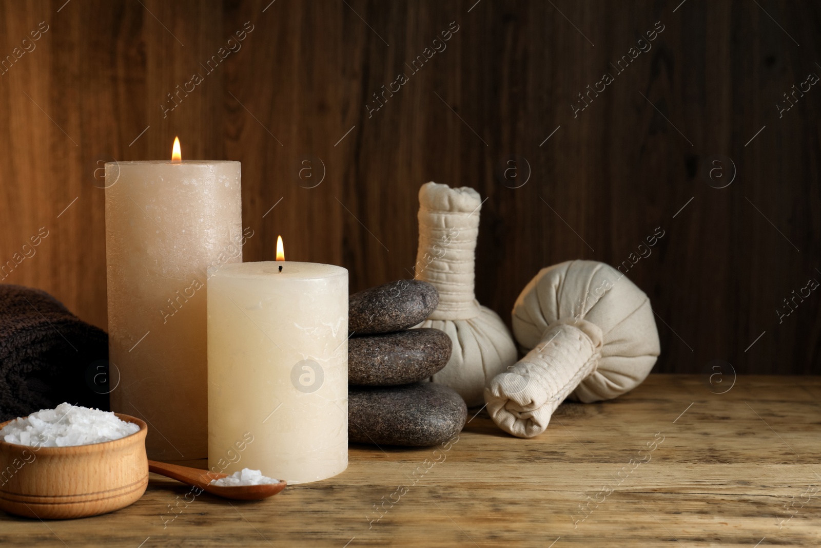 Photo of Beautiful spa composition with burning candles and sea salt on wooden table