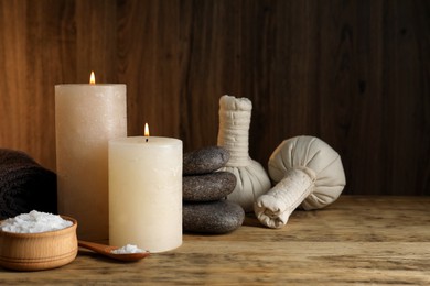 Photo of Beautiful spa composition with burning candles and sea salt on wooden table