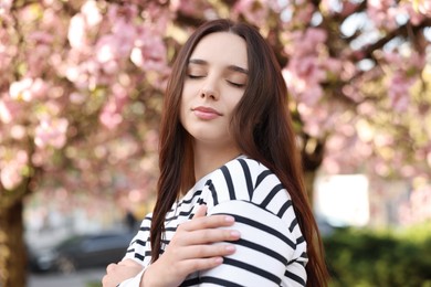 Photo of Beautiful woman near blossoming tree on spring day