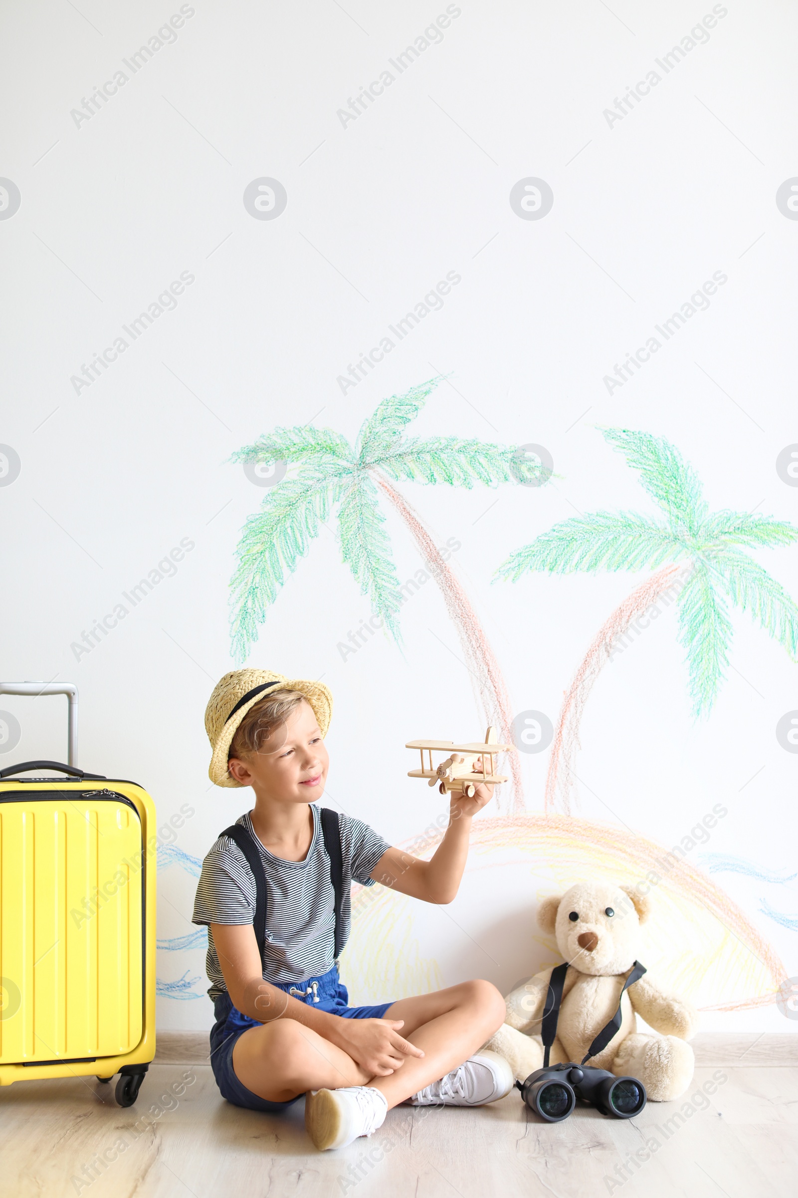 Photo of Adorable little child playing with toy airplane indoors