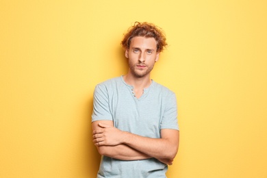 Photo of Young man in casual clothes posing on color background