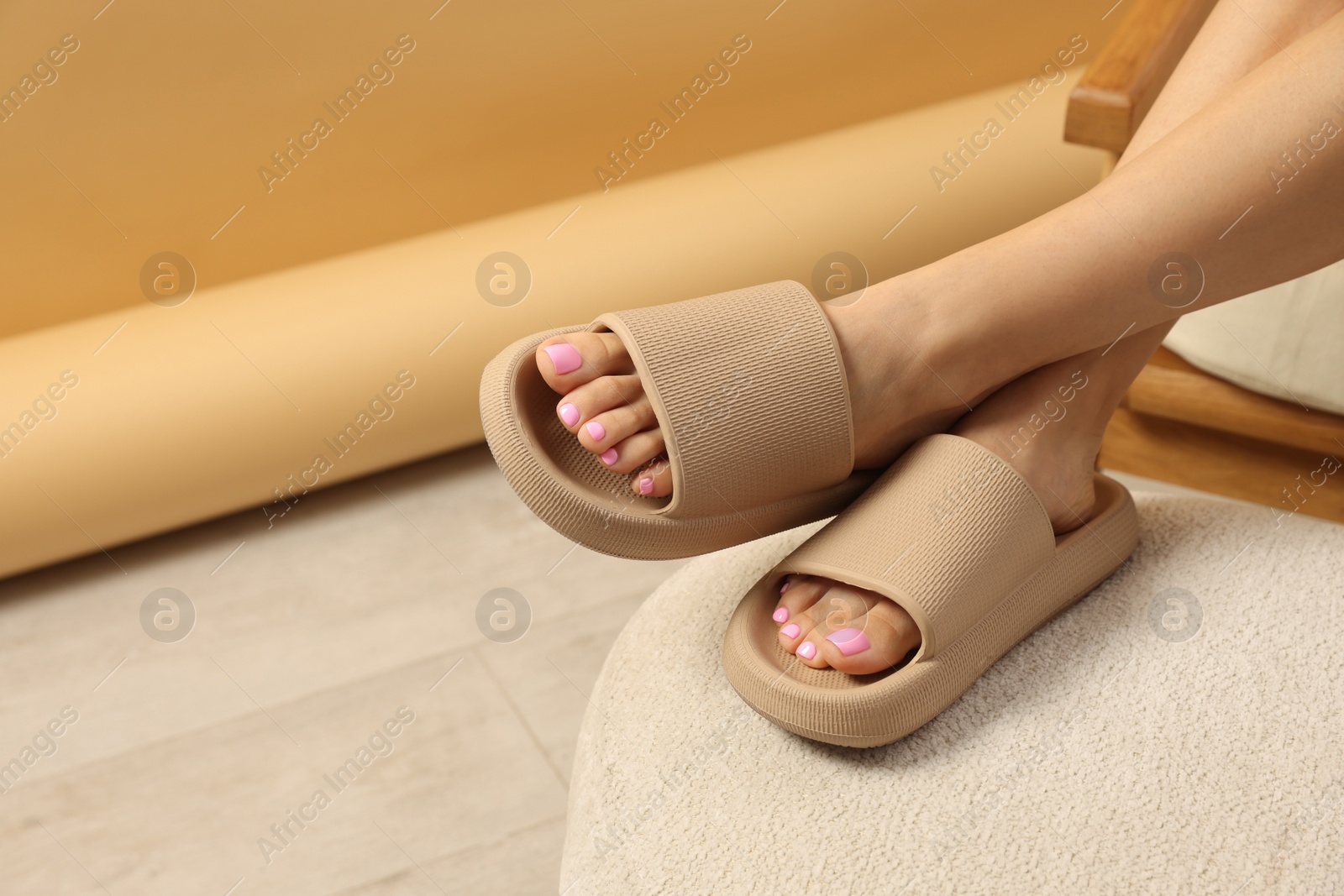 Photo of Woman wearing comfortable rubber slippers indoors, closeup. Space for text