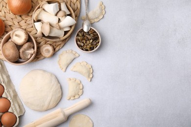 Process of making dumplings (varenyky) with mushrooms. Raw dough and ingredients on white table, flat lay. Space for text