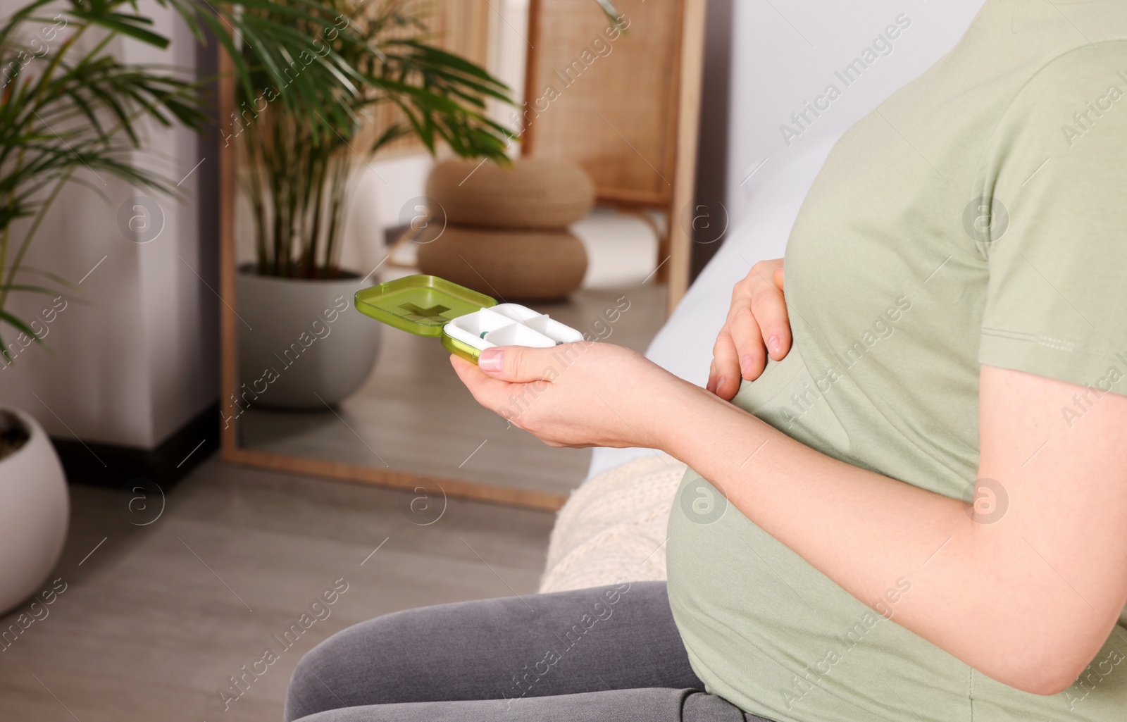 Photo of Pregnant woman taking pills at home, closeup. Space for text