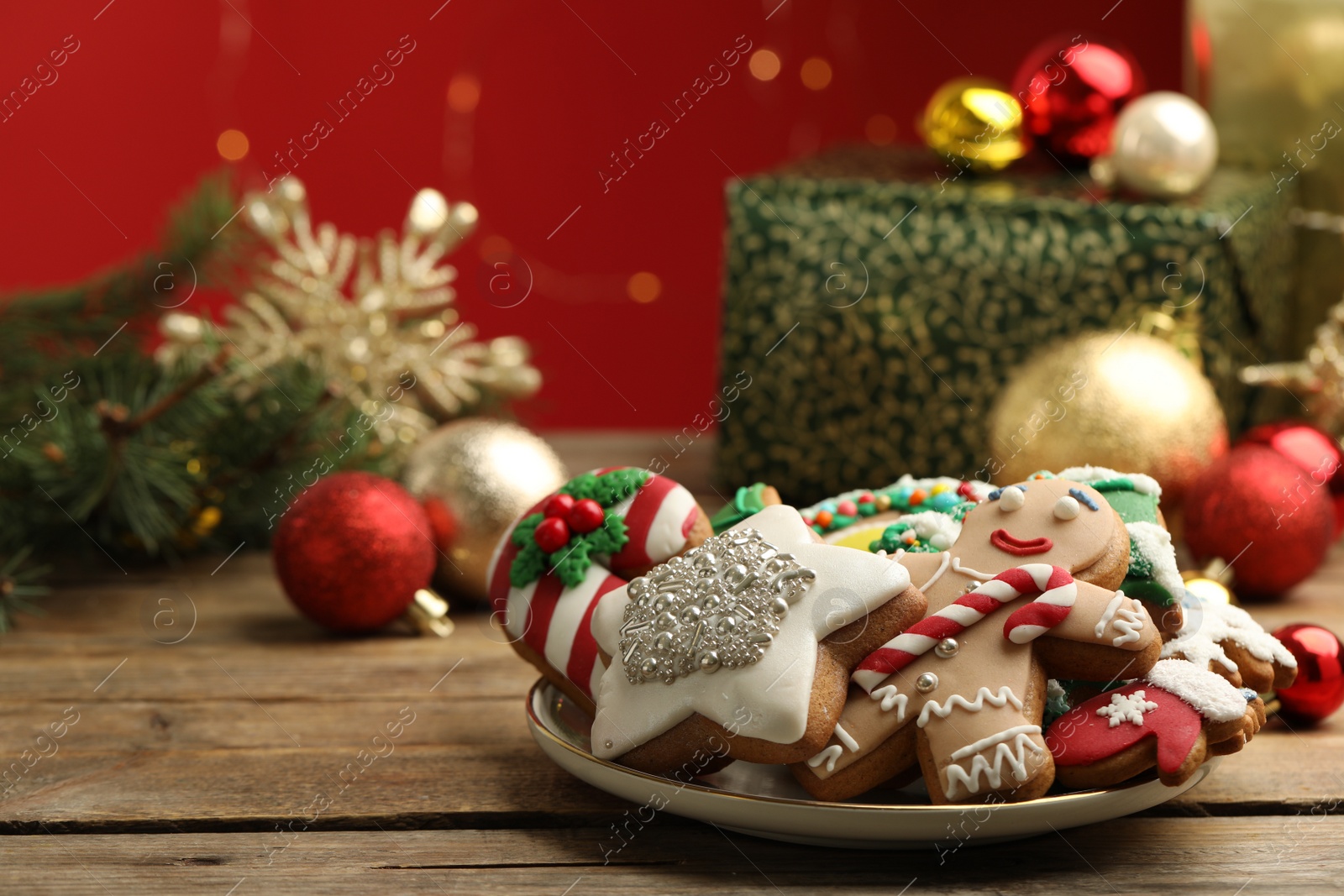 Photo of Sweet Christmas cookies and decor on wooden table against blurred festive lights
