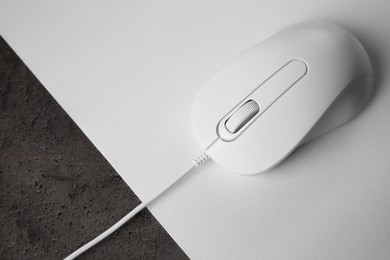 Photo of Wired mouse with mousepad on black textured table, top view