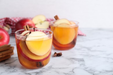 Photo of Aromatic hot mulled cider on white marble table. Space for text