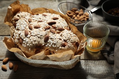 Photo of Delicious Italian Easter dove cake (traditional Colomba di Pasqua) and ingredients on wooden table