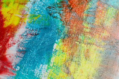 Photo of Strokes of colorful acrylic paints on canvas, closeup