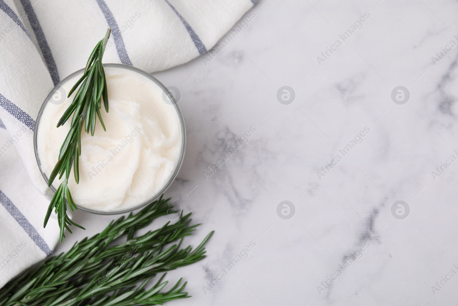 Photo of Delicious pork lard with rosemary in glass on white marble table, flat lay. Space for text