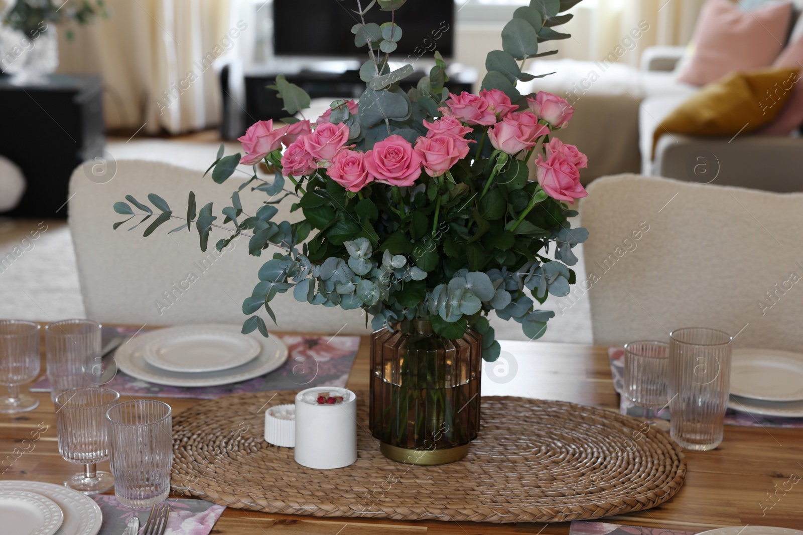 Photo of Beautiful table setting with bouquet of roses, napkins and candles in room