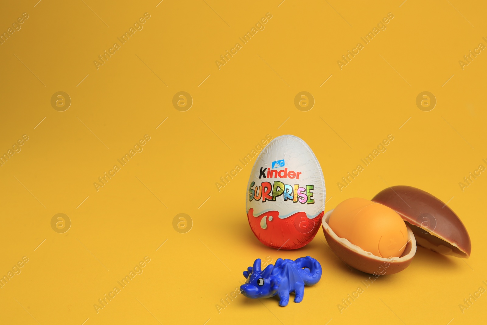 Photo of Sveti Vlas, Bulgaria - July 3, 2023: Kinder Surprise Eggs, plastic capsule and toy on yellow background, space for text