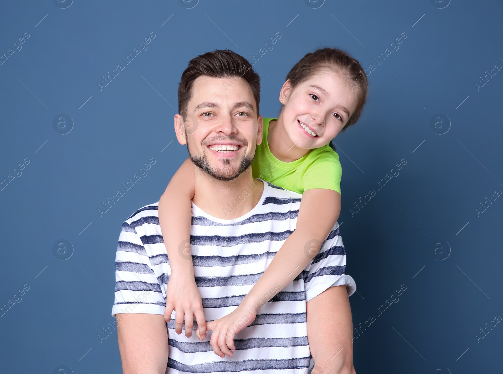 Photo of Dad and his daughter hugging on color background. Father's day celebration