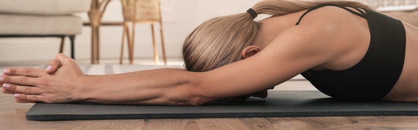 Image of Woman practicing yoga in room at home. Horizontal banner design 