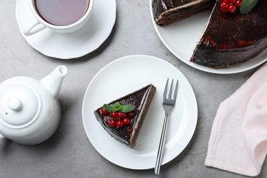 Tasty chocolate cake with berries on grey table, flat lay