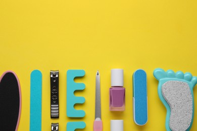 Photo of Set of pedicure tools on yellow background, flat lay. Space for text
