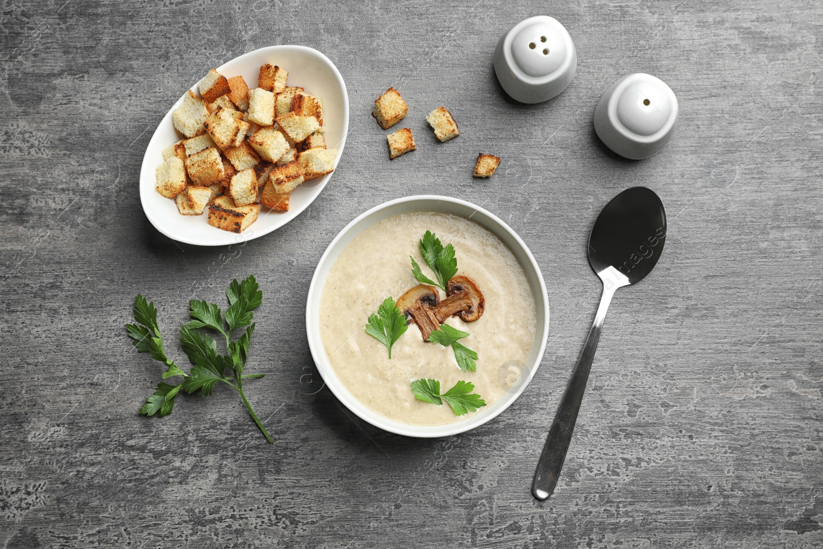 Photo of Flat lay composition with bowl of fresh homemade mushroom soup on gray background