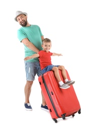 Photo of Man and his son playing with suitcase on white background. Vacation travel
