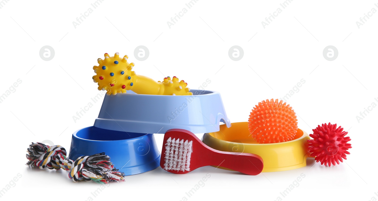 Photo of Feeding bowls, brush and dog toys on white background