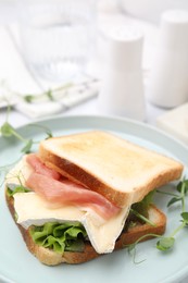 Photo of Tasty sandwich with brie cheese and prosciutto on table, closeup. Space for text