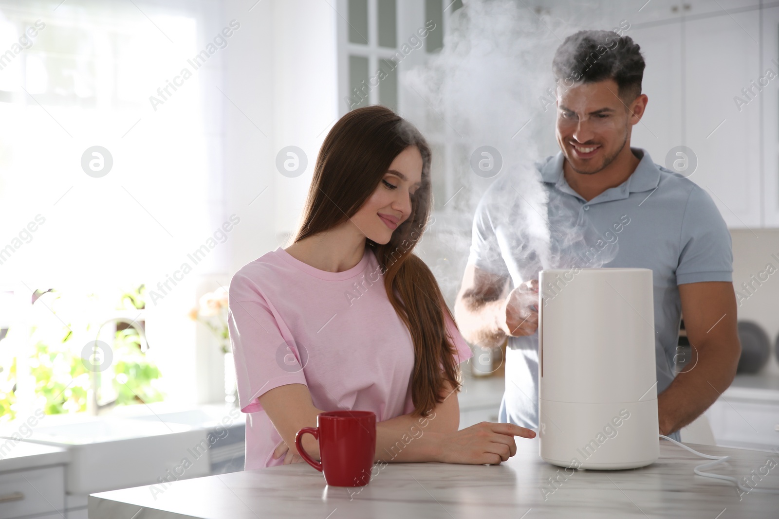 Photo of Couple in kitchen with modern air humidifier