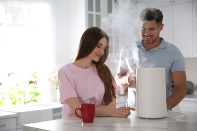 Couple in kitchen with modern air humidifier