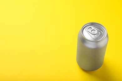 Photo of Can of energy drink on yellow background. Space for text