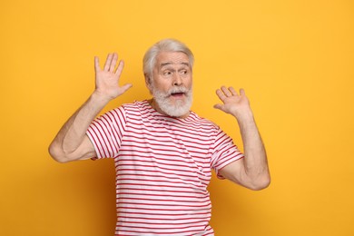 Photo of Senior man with mustache on orange background