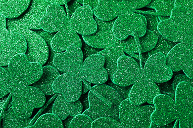 Photo of Glitter green clover leaves as background, top view. St. Patrick's Day celebration