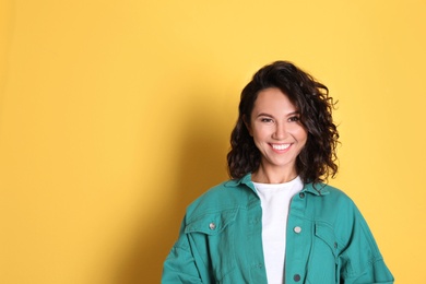 Photo of Happy young woman in casual outfit on yellow background