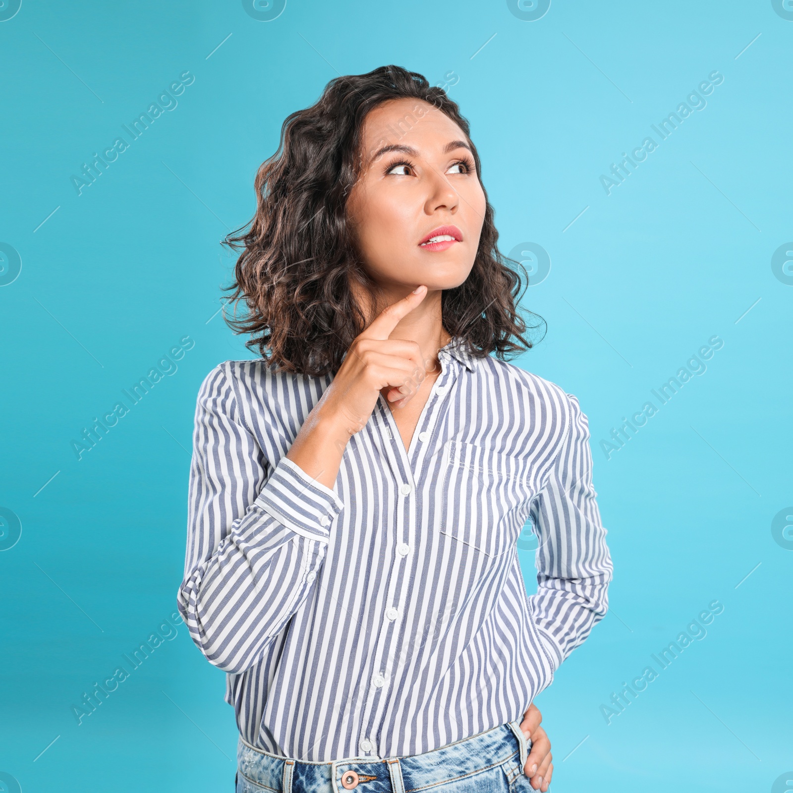 Photo of Thoughtful young woman in casual outfit on blue background