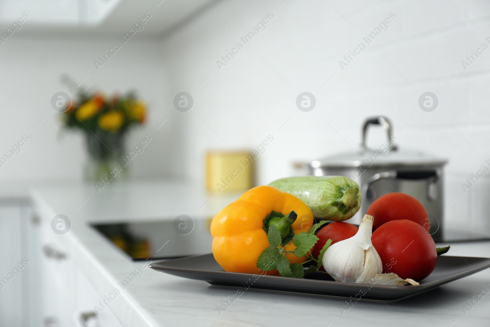 Photo of Different fresh vegetables on countertop in modern kitchen. Space for text