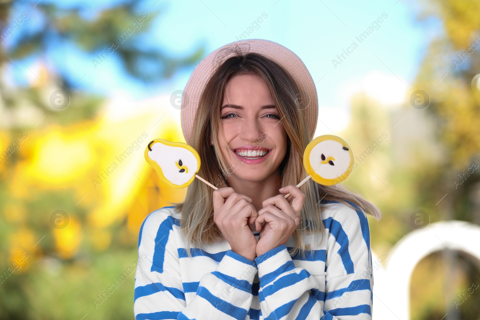 Photo of Young happy woman with sweet candies outdoors