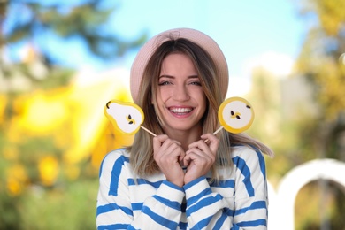 Young happy woman with sweet candies outdoors