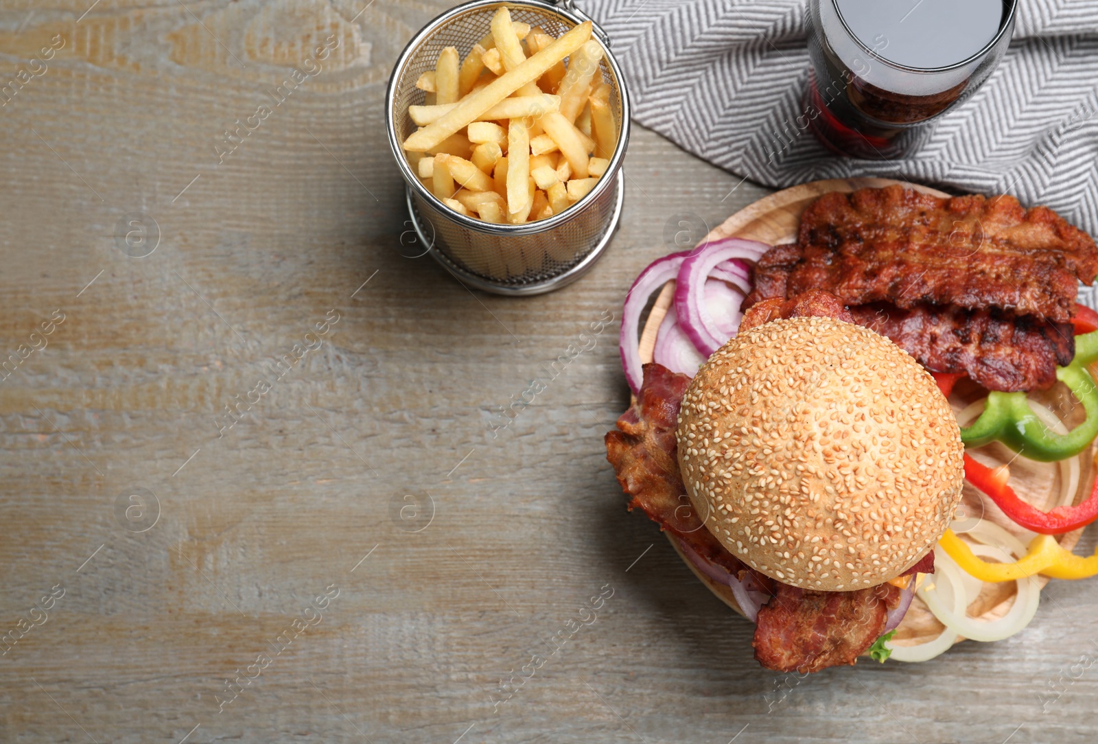 Photo of Flat lay composition with juicy bacon burger on wooden table. Space for text