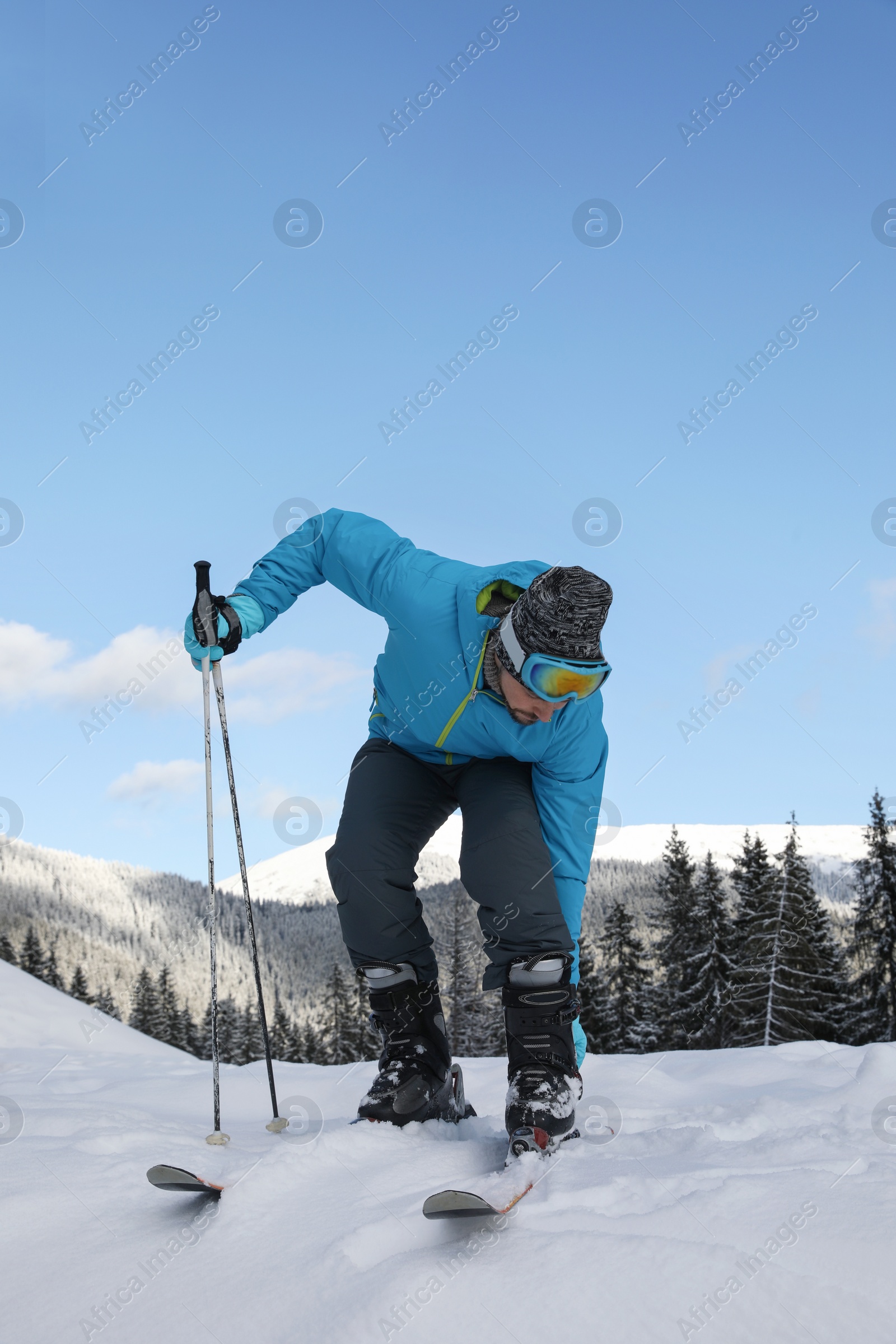 Photo of Man with ski equipment spending winter vacation in mountains