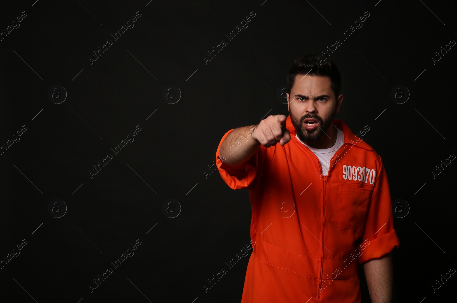 Photo of Prisoner in jumpsuit on black background, space for text