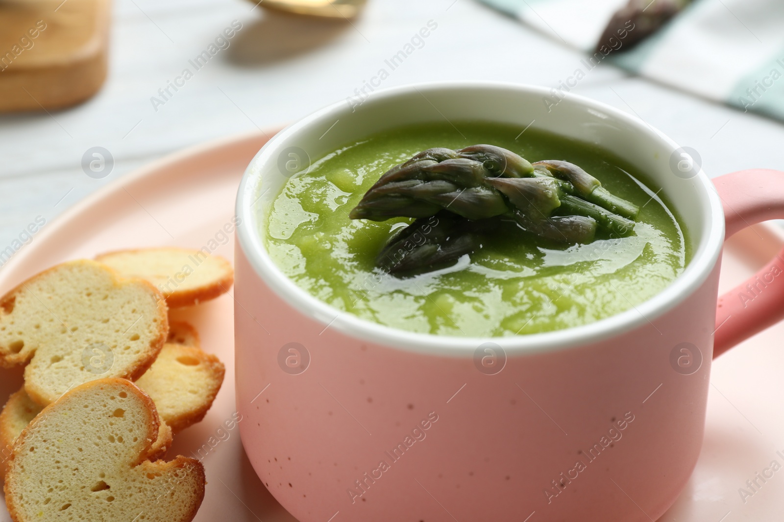 Photo of Delicious asparagus soup served on table, closeup