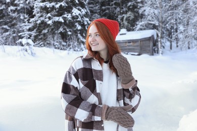 Portrait of beautiful young woman on snowy day outdoors. Winter vacation