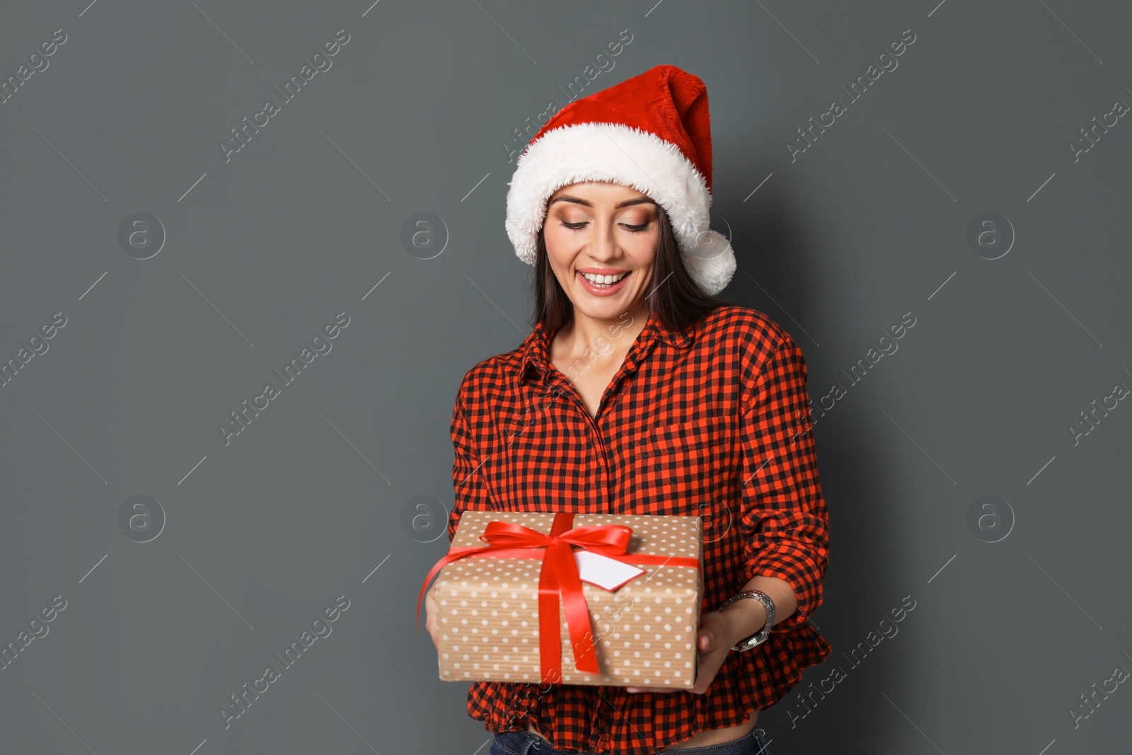 Photo of Young woman with Christmas gift on grey background