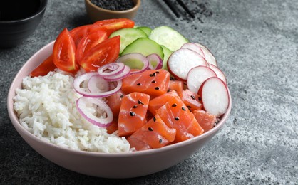 Photo of Delicious poke bowl with salmon and vegetables served on grey table