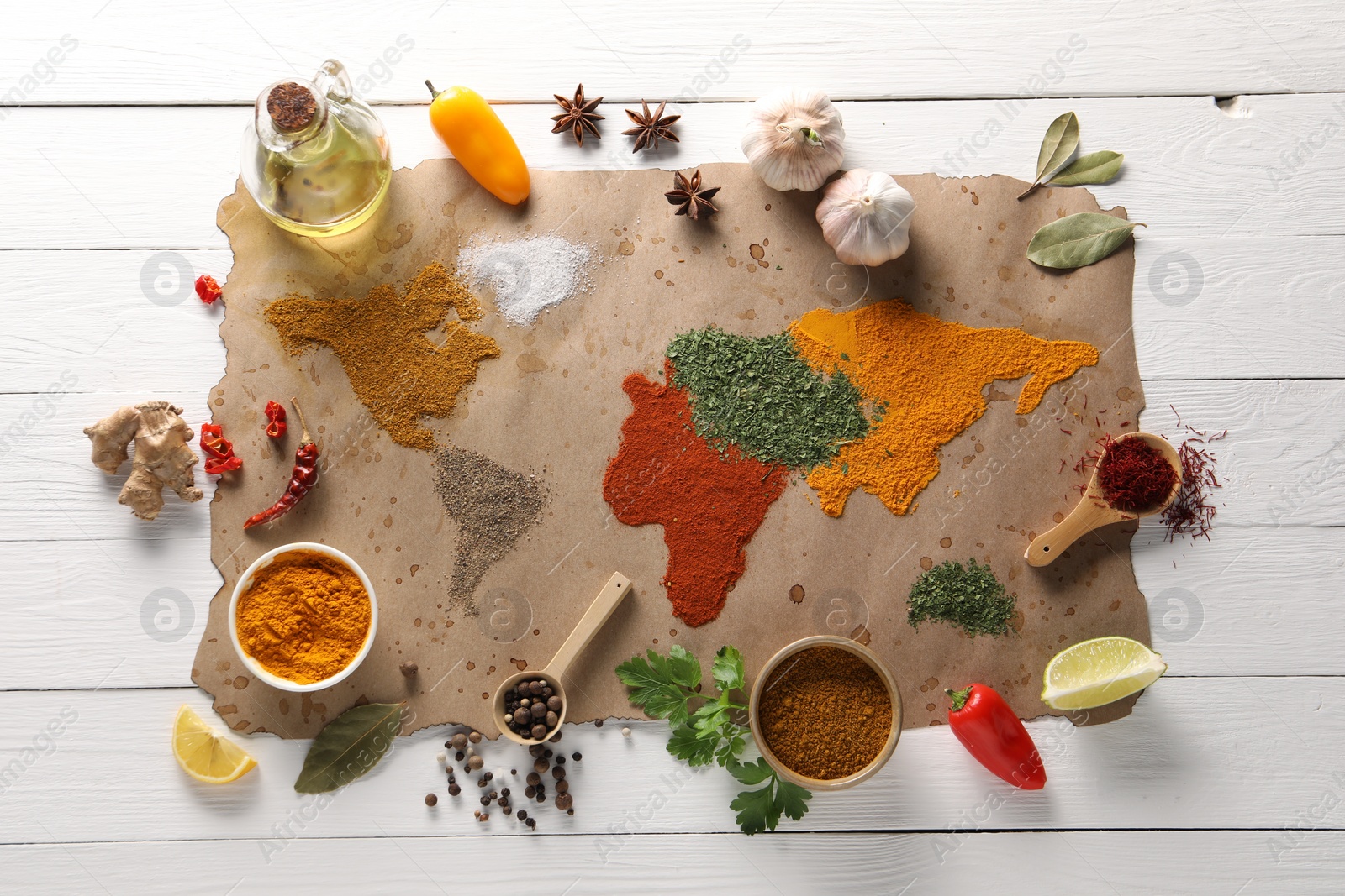 Photo of World map of different spices and products on white wooden table, top view
