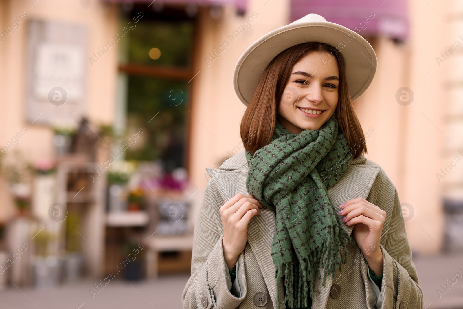 Photo of Beautiful woman in warm scarf and hat outdoors