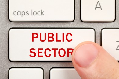 Image of Man pressing button with text Public Sector on computer keyboard, closeup