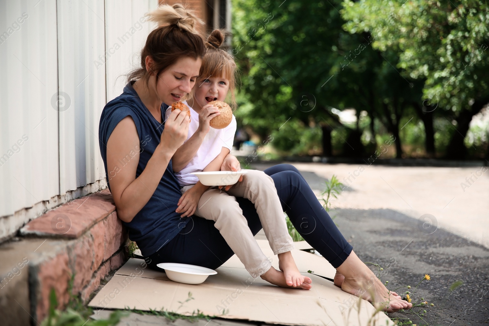 Photo of Poor people eating donated food on street