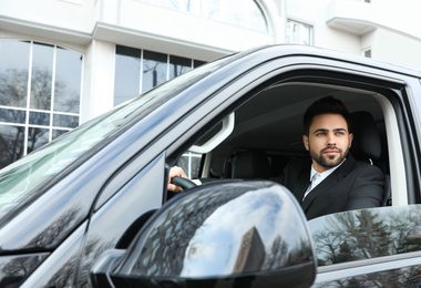 Photo of Handsome young man driving his modern car