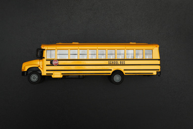 Photo of Yellow school bus on black background, top view. Transport for students